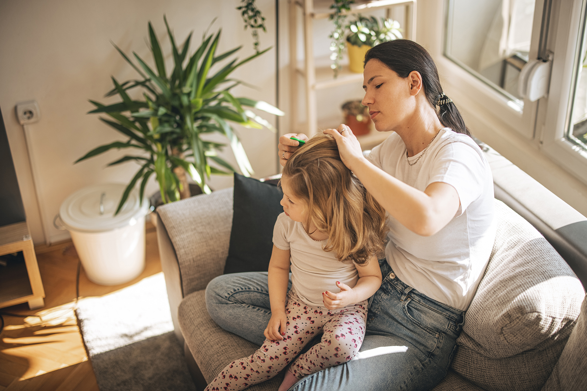 A child and mother at home on the couch – how to detect and eliminate head lice